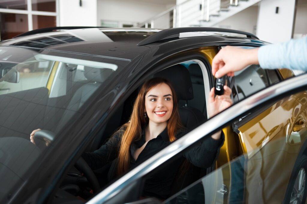 Car dealership seller gives client a car key