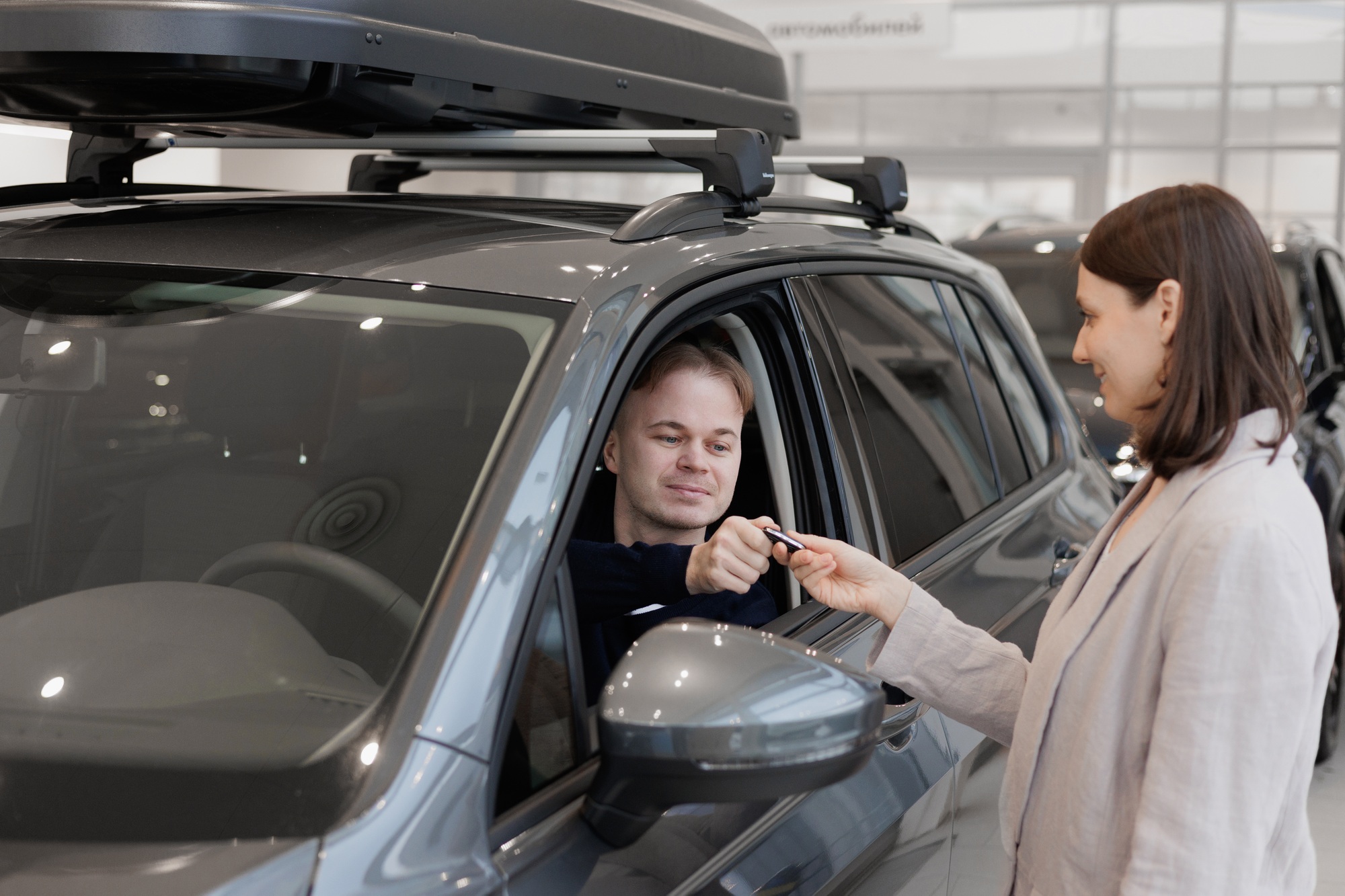 female salesperson and car rental helps with the purchase. signing a trade-in contract and handing