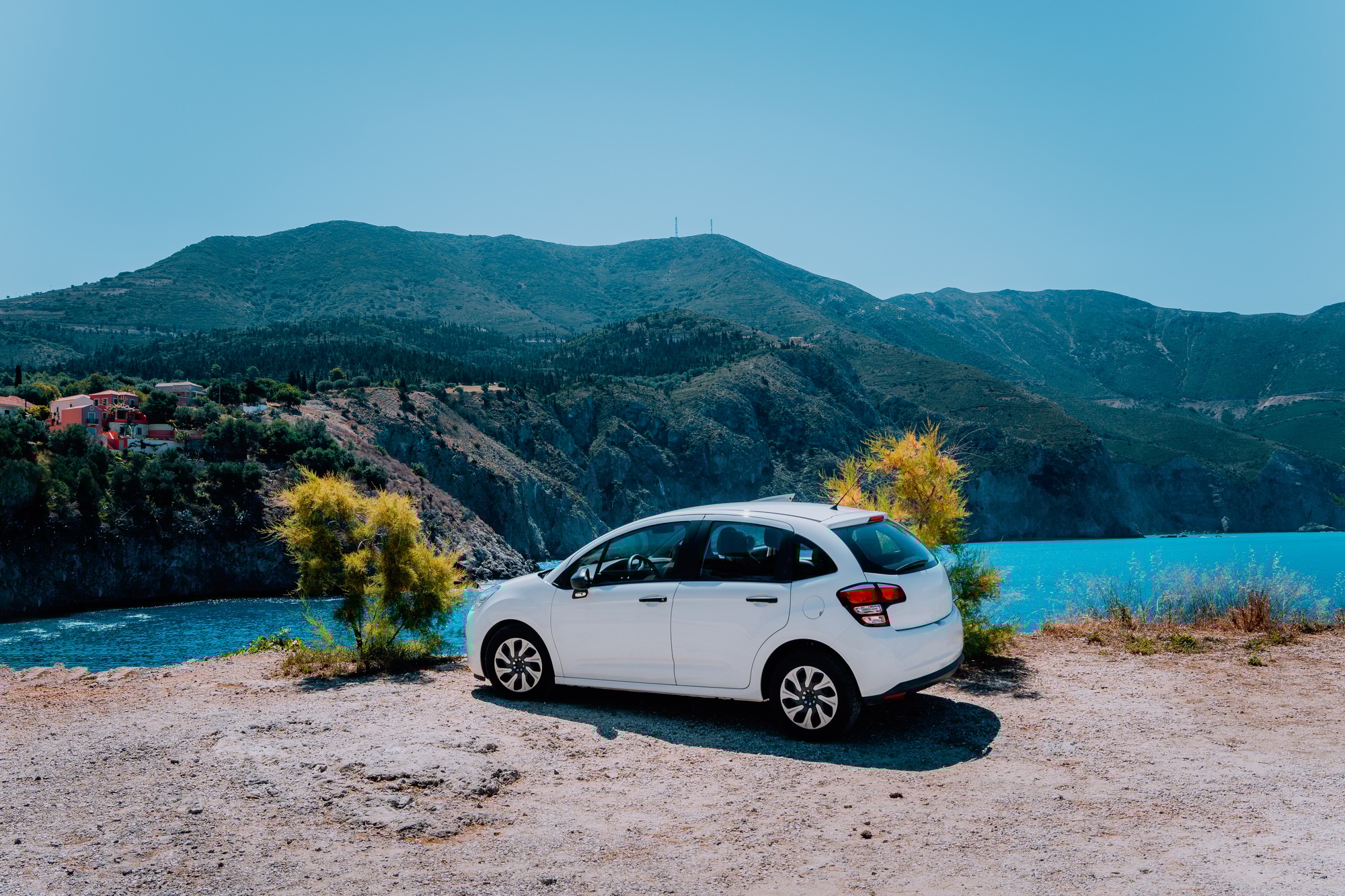 Vacation travel with car concept. Rental hired car in front of amazing bay with turquoise water
